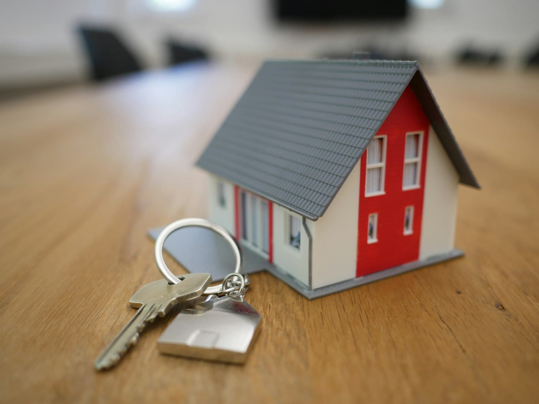 Clés d'un logement posées à côté d'une maquette de maison
